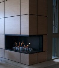 A Real Flame Hybrid Gas Log Fire installed against a wood-paneled wall, one of the best gas fireplaces for autumn warmth