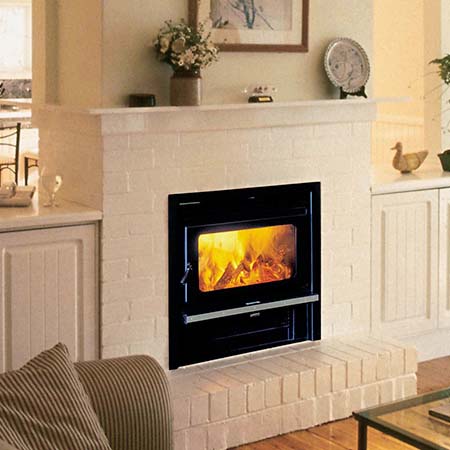 Kemlan Coupe Double Sided Inbuilt stove centered in a cosy room with a traditional fireplace setting, one of the best wood heaters for autumn