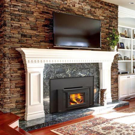 A cosy living room with a Heatilator wood-burning insert topped with a TV, among the best wood heaters for autumn comfort