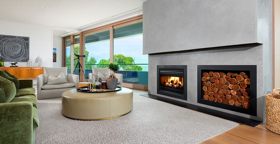 A cosy living room with a green couch and open wood fireplace, creating warmth and comfort with the best wood heaters for autumn