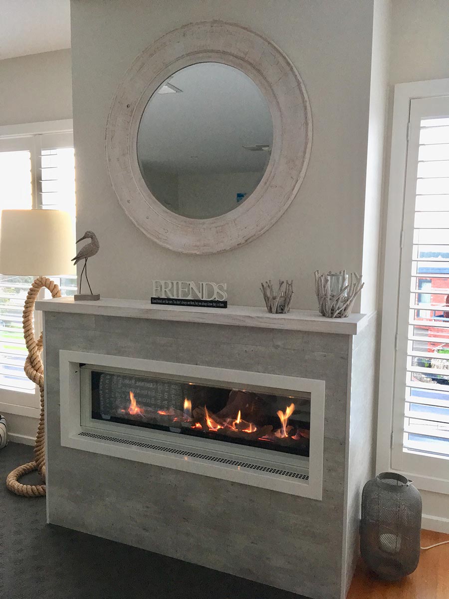 Real Flame Element 1200 with glowing fire and mirror above, one of the best gas fireplaces for autumn warmth in any home