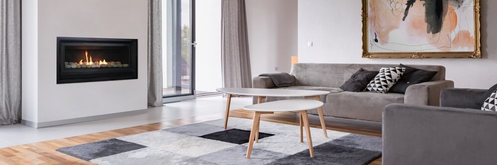 A living room with a Real Flame Inspire 1100 fireplace, complemented by a warm wooden floor and inviting decor
