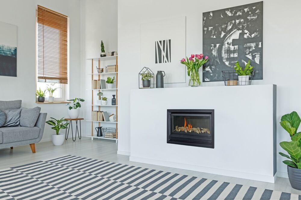 A living room with a Real Flame Inspire 700 fireplace and a stylish grey sofa