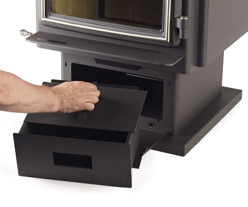 A person opens the ash drawer of a Regency Windsor™ Wood Freestanding, preparing for maintenance