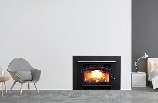 A serene bedroom with a corner fireplace - Quadra-Fire Expedition II Wood Fire adding warmth and comfort to the space