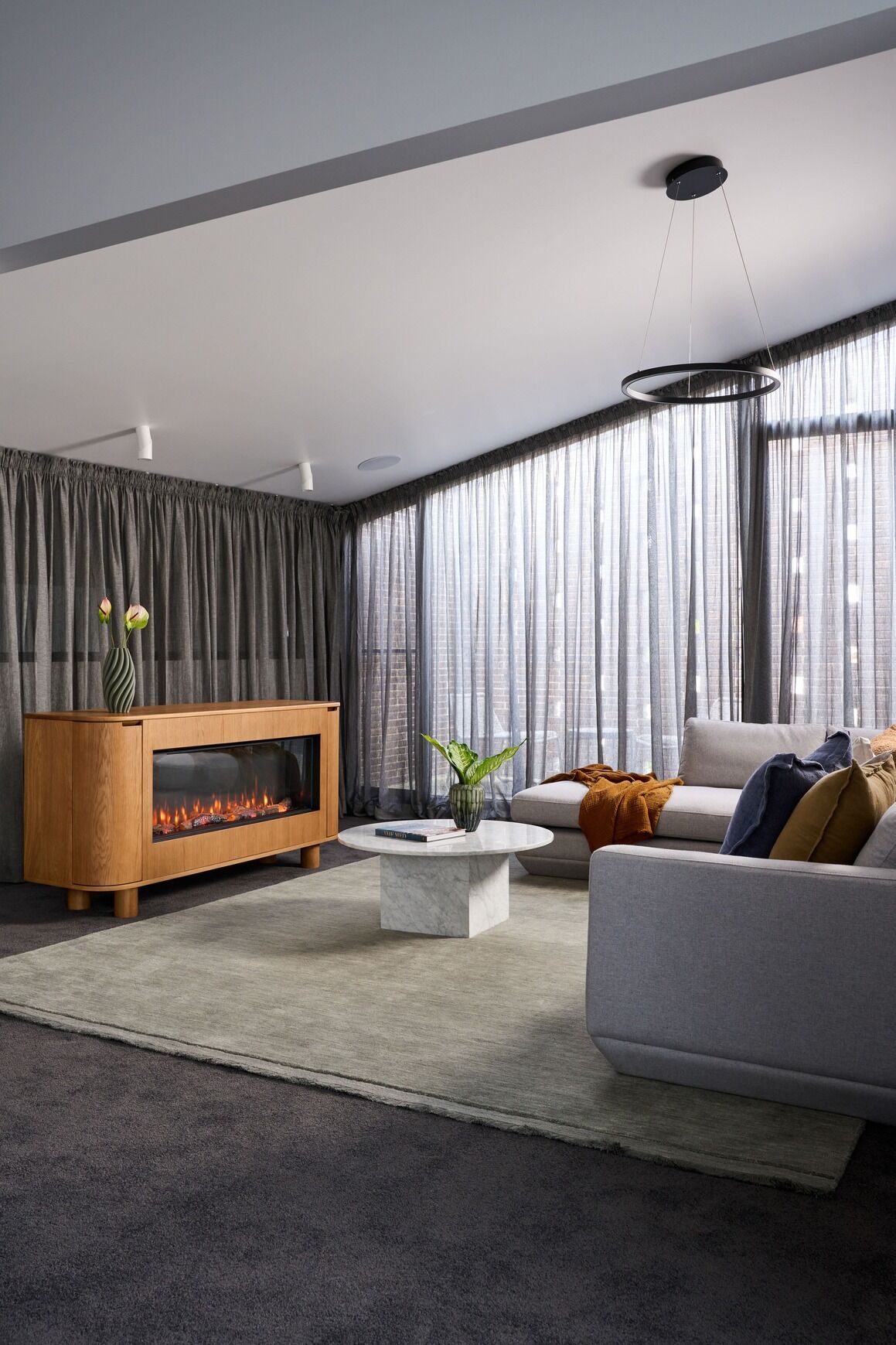 Modern living room with an EmberArc Ashton 180 electric fireplace and stylish couch, creating a warm and inviting atmosphere